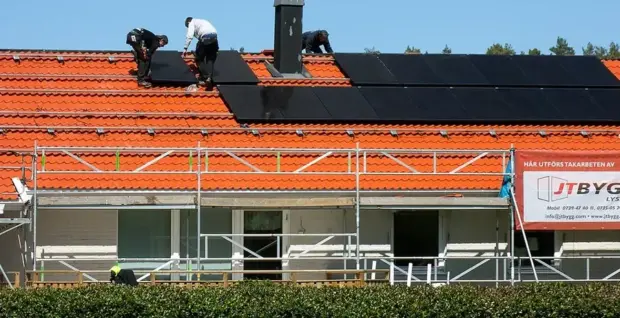 Instalador montando paneles solares sobre una cubierta