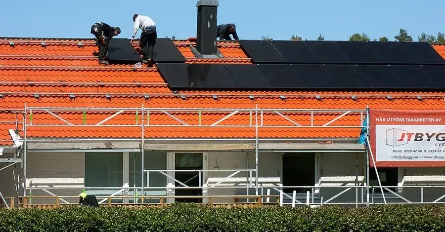 Instalador montando paneles solares sobre una cubierta